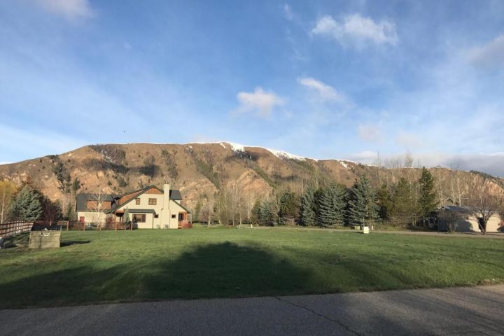 empty lot for sale with mountains and green grass