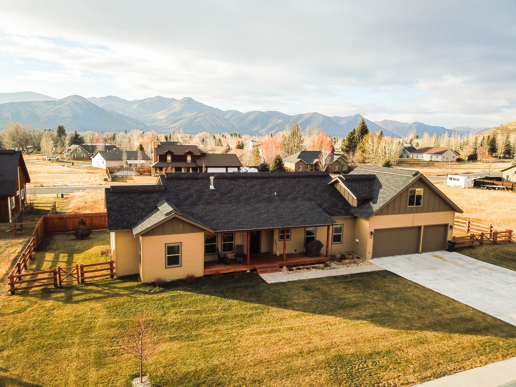 aerial shot of a brown home and front yard
